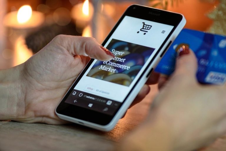 Shopper paying on a smartphone with a card in hand