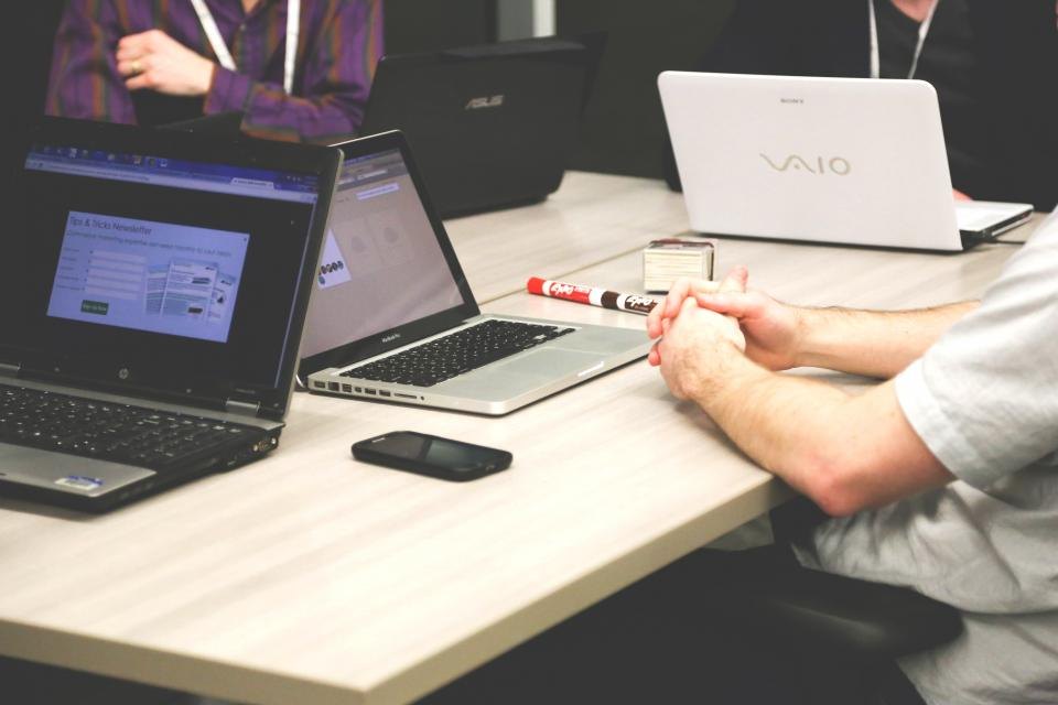 Team collaborating around laptops at a meeting table