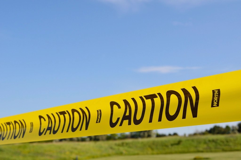 Yellow caution tape stretched across an open field