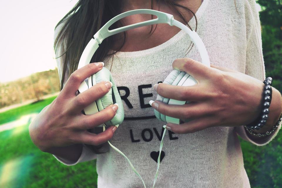 Young woman holding a pair of headphones